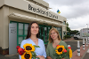 two women holding sunflower outside Breckland Council offices