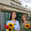 two women holding sunflower outside Breckland Council offices