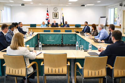 People seated round tables in a hollow square